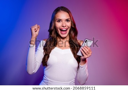 Photo of astonished lady hold telephone cheering goal win wear white shirt isolated neon gradient color background