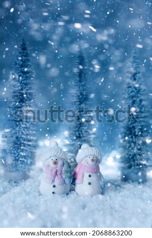 toy snowmen with a Christmas tree in a snowy forest