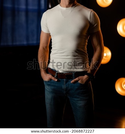 Stylish fashionable unrecognizable man in jeans and a white T-shirt.
