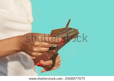 Female hands cut a stack of credit cards with scissors. Selective focus image. The concept of getting rid of loans, refusing to use cards, shopaholism. Royalty-Free Stock Photo #2068877075