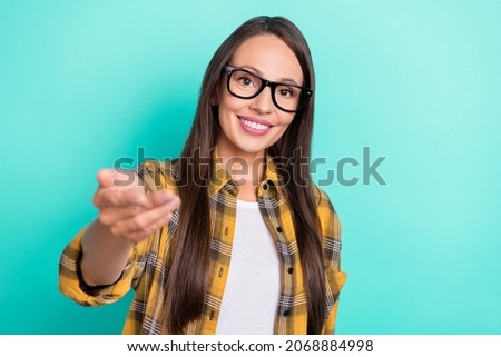 Photo of optimistic young lady invite you wear spectacles yellow shirt isolated on turquoise color background