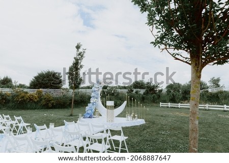 photo zone of blue and white colors. in the middle there is a white path, there are chairs around