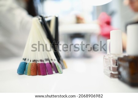 Close-up of various colours presented on palette. Glass tubes with professional nail polish. Care treatment. Qualified masters. Beauty salon manicure and pedicure concept