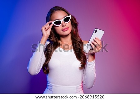 Photo of shiny cool young lady dressed off-shoulders shirt arm dark eyewear typing modern device isolated filter red blue color background