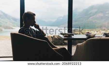 silhouetted man sitting at dinner table with beautiful view