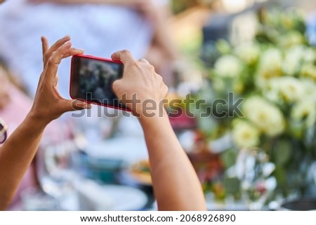 The girl takes pictures on a mobile phone. 