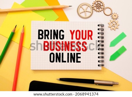 bring your business online. text on white paper on wood background near calculator, paper clips, alarm clock, glasses
