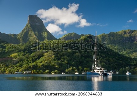 Paradise location in tropical island, Cook's Bay in Moorea, French Polynesia, on a sunny day with blue skies, beautiful mountains in the background with superyachts at anchor.  Royalty-Free Stock Photo #2068944683