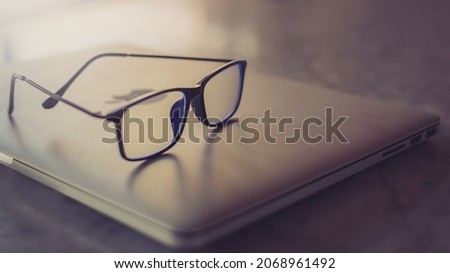 Picture of a laptop with glasses on the table.online work concept