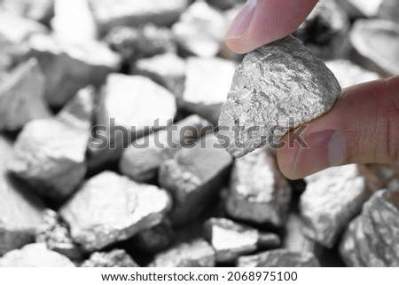Miners hold in their hands platinum or silver or rare earth minerals found in the mine for inspection and consideration Royalty-Free Stock Photo #2068975100