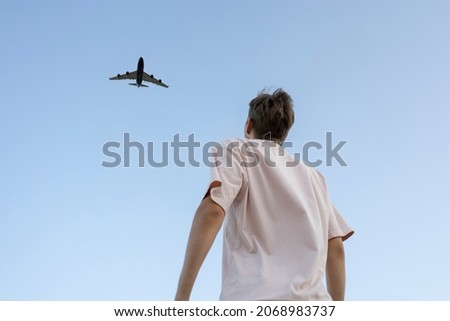 man looking up in the sky and cheer the airplane  Royalty-Free Stock Photo #2068983737