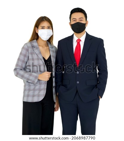 Asian businessman in a suit and face mask stand in his pocket with a confident expression. A colleague in gray suit stood beside him. Portrait on white background with studio light.