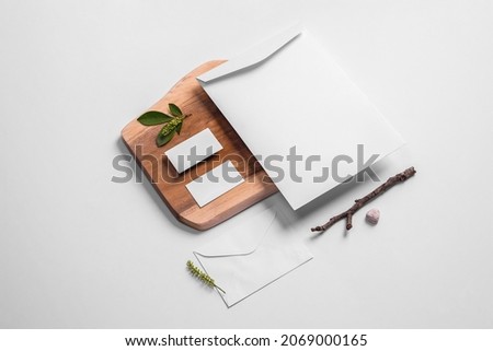 Wooden branding mockup, stationery branding mockup template for design projects with leaves, stick, pencil, rocks, wood, letter envelope, envelope A4 and business card in gray neutral background