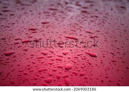Raindrops Lie on a Red Metal Surface, Forming a Unique Patttern