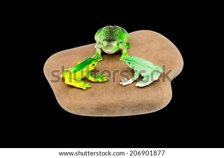 toy frogs on a stone