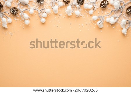 Top view photo of christmas decorations snow covered branches with pine cones on isolated beige background with blank space