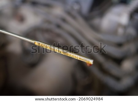 Oil probe of the car with a drop of engine oil. Maintenance of the car in the garage. Royalty-Free Stock Photo #2069024984