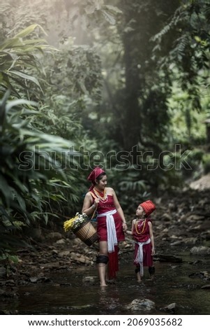 Two red Karen mother and daughter We walk home happily together at the stream and waterfall. Mae Hong Son Province, Thailand