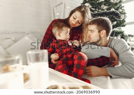 Beautiful family sitting on bed hugging and eating cookies