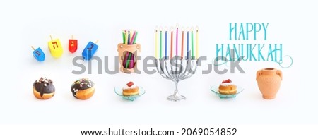 Religion image of jewish holiday Hanukkah with menorah (traditional candelabra), doughnut and candles over white background