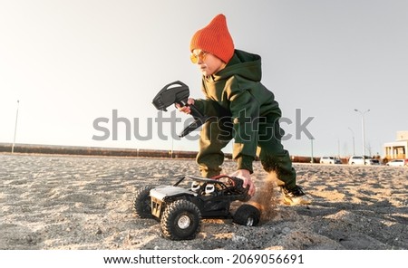 Male kid holding radio controlled wireless drive high speed sport car toy and joystick Royalty-Free Stock Photo #2069056691