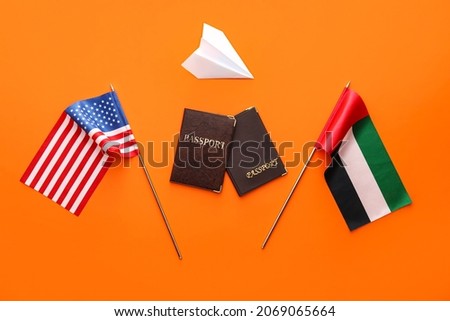 National UAE, USA flags, paper plane and passports on red background