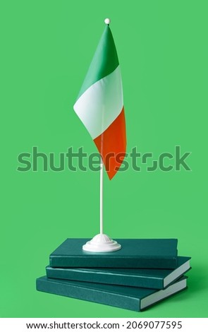 Italian flag and books on color background