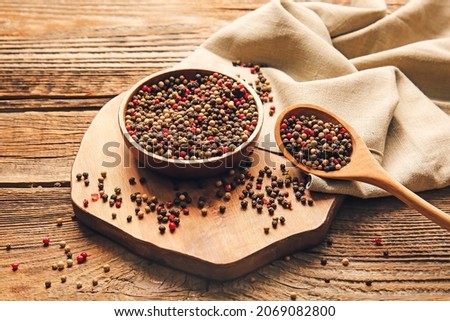 Bowl and spoon with mixed peppercorns on wooden background Royalty-Free Stock Photo #2069082800