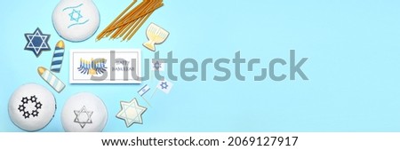 Different symbols of Hanukkah and greeting card on color background with space for text