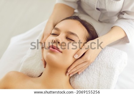 Woman on massage bed or examination table getting cosmetic facial treatment for evening out skin tone, rejuvenating, lifting skin and brightening complexion for clear smooth fresh perfect glowing skin Royalty-Free Stock Photo #2069155256