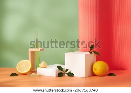 Lemon extract white podium in a test tube with green background with green leaf , sliced lemon , blank space for advertising , front view
