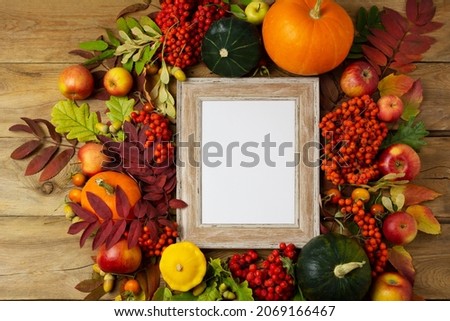 Wooden small frame mockup with apples, pumpkins and fall leaves. Empty frame mock up for presentation artwork. Template framing for modern art