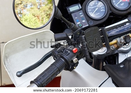 fragment of a motorcycle handlebar with switches and a rear-view mirror
