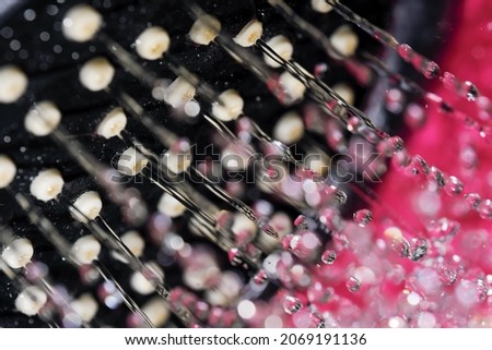 Hand shower head close-up with water jets flowing out of holes macro photography with short exposure
