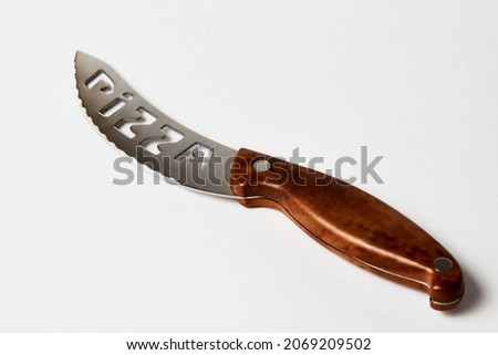 Pizza knife isolated on a white background with copy space, close-up. Pizza knife with wooden handle