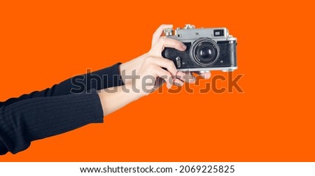 Vintage Camera in female hand. Colored background