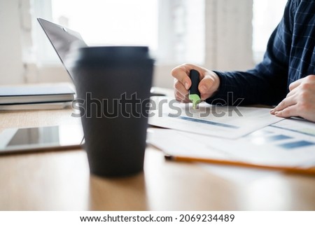 An open laptop with graphs and tables online. Workplace in the office with documents. A man working on the stock exchange uses.  The report for the month of finance.
