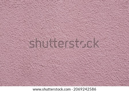 Full frame image of cement or concrete wall painted pink color. High resolution seamless texture of textured relief plaster for 3d models, background or collage, copy space