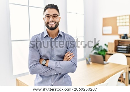 Young arab man smiling confident standing with arms crossed gesture at office Royalty-Free Stock Photo #2069250287