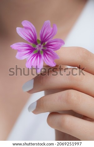 girl with daisy ring holding purple flower