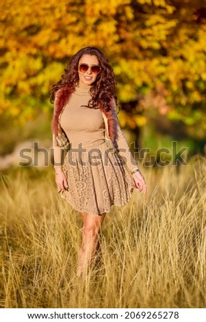 a beautiful elegant woman posing on a sunny autumn day.