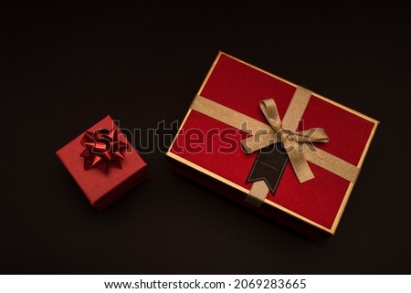 Creative look, red and black gift boxes on a black background. Black friday, discounts, sales, christmas shopping on a black background, two red gift boxes top view.