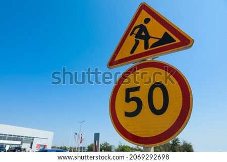 Road construction and speed limit signs outdoors on sunny day. Repair works