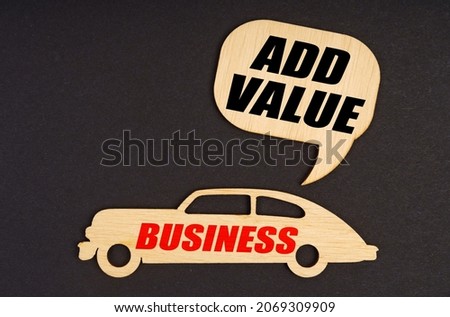 Business and finance concept. On a black background, a car with the inscription Business, above it a plate with the inscription - Add Value