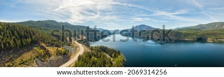 Aerial panoramic view of a scenic highway around mountains. East Kootenay, British Columbia, Canada. Royalty-Free Stock Photo #2069314256