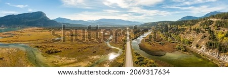 Aerial panoramic view of a scenic highway around mountains. East Kootenay, British Columbia, Canada. Royalty-Free Stock Photo #2069317634