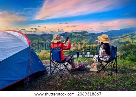Couple tourists enjoying in the camping on mountains, Traveler take a photo at viewpoint.
