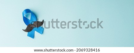 Top panoramic view photo of blue ribbon and mustache shape symbol of prostate cancer awareness on isolated pastel blue background with empty space