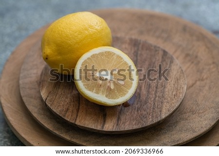 Citrus lemons on the wooden plates on the vintage table.