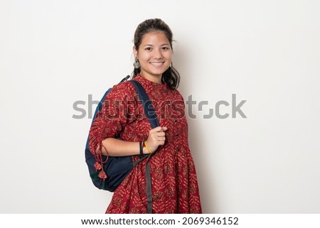 Young indian girl getting ready to go to college, college girl with a bag on white background.